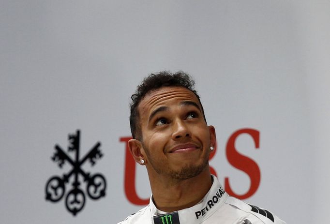 First-placed Mercedes Formula One driver Lewis Hamilton of Britain looks up as he stands on the winners' podium during the Chinese F1 Grand Prix at the Shanghai Internati