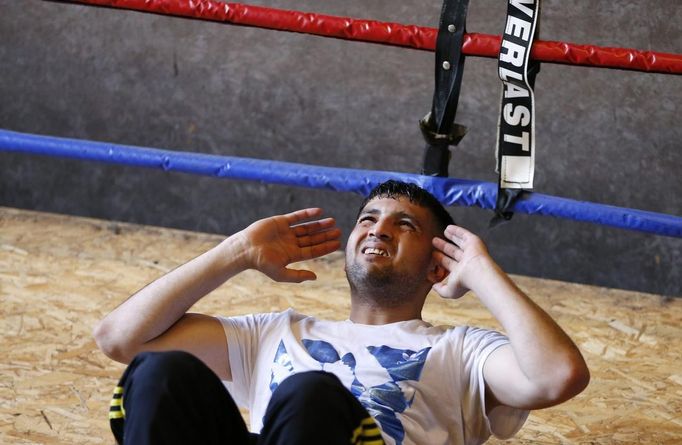 Unemployed Belgian Mohamed Sammar stretches as he takes part in a "Fit for a job" boxing class in Brussels June 14, 2013. Sammar, 27, has been looking for a job in the construction sector for 2 years. "Fit for a job" is the initiative of former Belgian boxing champion Bea Diallo, whose goal was to restore the confidence of unemployed people and help them find a job through their participation in sports. Picture taken June 14, 2013. REUTERS/Francois Lenoir (BELGIUM - Tags: SPORT BOXING SOCIETY BUSINESS EMPLOYMENT) Published: Čec. 5, 2013, 3:58 odp.