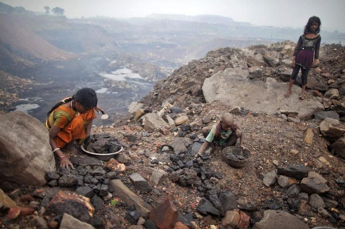 Locals collect coal from an open cast coal field at Dhanbad district in the eastern Indian state of Jharkhand September 20, 2012. With oil and gas output disappointing and hydropower at full throttle, Asia's third-largest economy still relies on coal for most of its vast energy needs. About 75 percent of India's coal demand is met by domestic production and, according to government plans, that won't change over the next five years. Picture taken September 20, 2012. To match INDIA-COAL/ REUTERS/Ahmad Masood (INDIA - Tags: BUSINESS EMPLOYMENT ENERGY SOCIETY ENVIRONMENT) Published: Říj. 21, 2012, 10:20 odp.