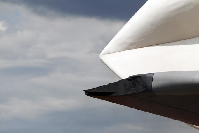 The damaged starboard wing of the Space Shuttle Enterprise is seen as it is lifted onto the deck of the Intrepid Sea, Air and Space Museum in New York June 6, 2012. The shuttle suffered minor wingtip damage when it grazed a bridge's protective piling while being transported from JFK airport to a marina in New Jersey on Sunday, according to a spokesman for the Intrepid Museum. REUTERS/Eric Thayer (UNITED STATES - Tags: SCIENCE TECHNOLOGY TRANSPORT) Published: Čer. 6, 2012, 10:57 odp.