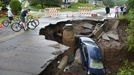 Heavy Flooding Hits Minnesota June 20, 2012 - Duluth, Minnesota, U.S. - People look at a car that was pulled into a sinkhole along skyline Parkway. With over 9 inches of rain overnight and into Wednesday morning washouts, sinkholes and mudslides appeared.