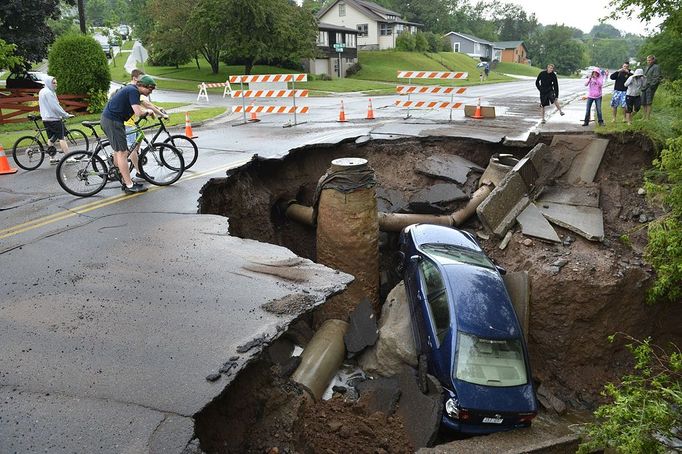 Heavy Flooding Hits Minnesota June 20, 2012 - Duluth, Minnesota, U.S. - People look at a car that was pulled into a sinkhole along skyline Parkway. With over 9 inches of rain overnight and into Wednesday morning washouts, sinkholes and mudslides appeared.