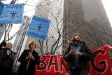 Nezabránily tomu ani protesty proti stavbě. Před týdnem se například v americkém New Yorku sešli demonstranti před budovou Mizuho Bank.