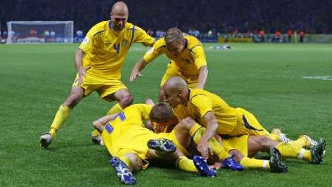 Fotbalisté Švédska se vrhají na střelce vítězné branky proti Paraguayi Fredrika Ljungberga.