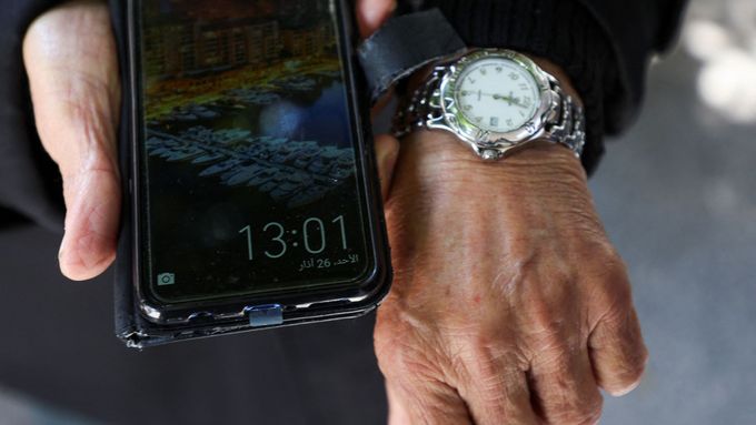 Libanonský muslim Mohamed al-Arab ukazuje na svých hodinkách a mobilu různé časy kvůli sporu mezi politickými a náboženskými autoritami ohledně zimního času