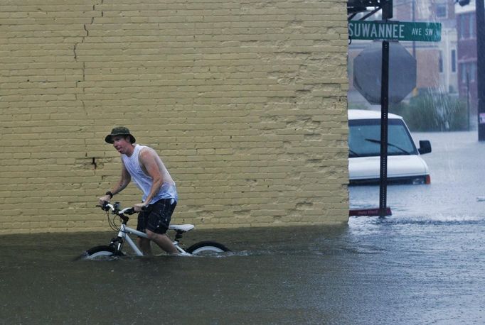 Phillip Roser struggles to pedal his bike in downtown Live Oak, Florida, June 26, 2012. Tropical Storm Debby drifted slowly eastward over Florida's Gulf Coast on Tuesday, threatening to dump more rain on areas already beset by flooding. After stalling in the Gulf of Mexico, the storm was finally moving but was expected to take two more days to finish its wet slog across Florida. REUTERS/Phil Sears (UNITED STATES - Tags: ENVIRONMENT TPX IMAGES OF THE DAY) Published: Čer. 26, 2012, 9:18 odp.