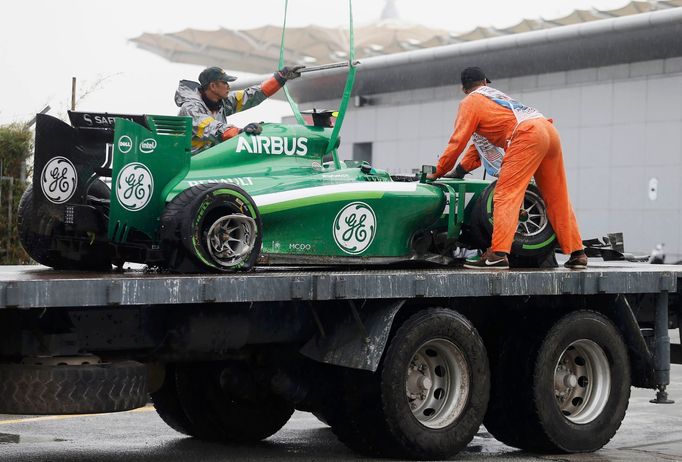 The car of Caterham Formula One driver Marcus Ericsson of Sweden is removed from the tracks after Ericsson crashed during the qualifying session for the Malaysian F1 Gran