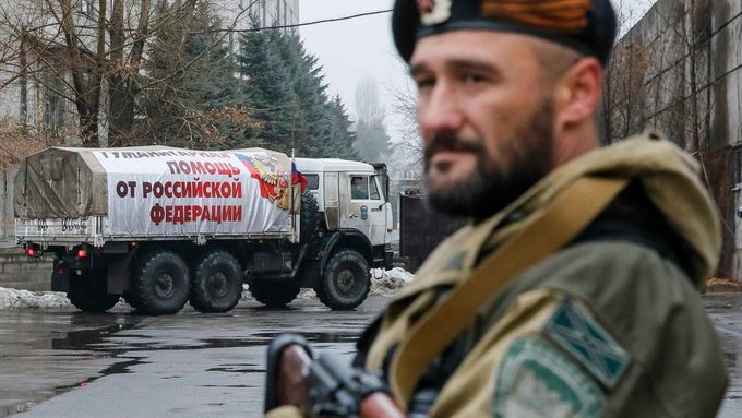 Proruský separatista hlídá v ulicích Makejevky, kterými právě projíždí ruský konvoj s humanitární pomocí.