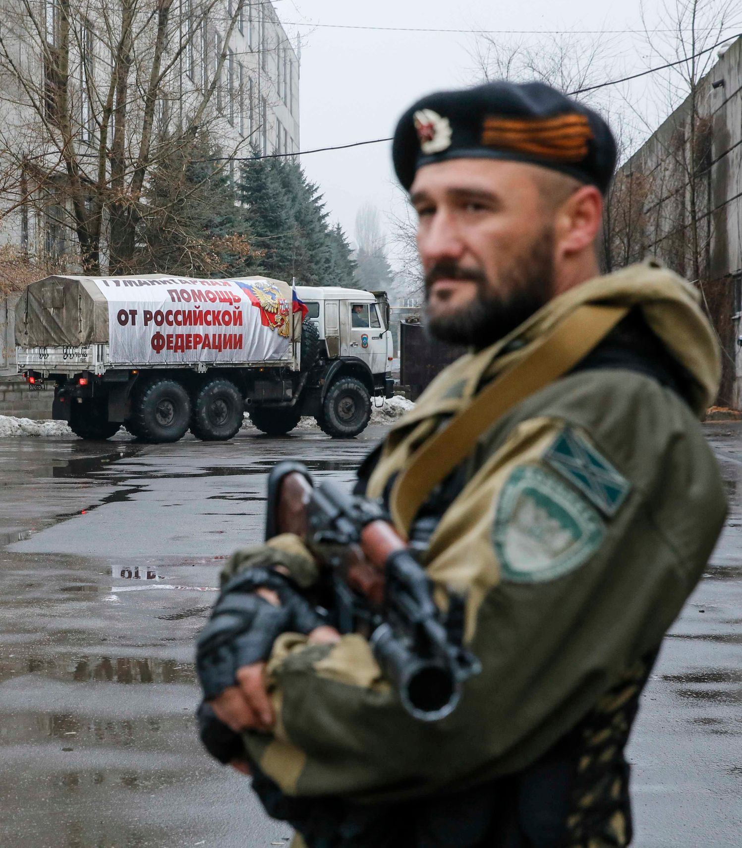Proruský separatista hlídá v ulicích, kterými právě projíždí ruský konvoj s humanitární pomocí.