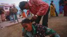 A man pulls a devotee, believed to be possessed by evil spirits, by the hair as she goes into a state of trance at Guru Deoji Maharaj temple during a ghost fair at Malajpur village in Betul district in the central Indian state of Madhya Pradesh January 27, 2013. People from across India come to this fair to be exorcised of �evil spirits�. They are usually brought by relatives and they are most often women. The exorcism involves running around the temple courtyard to make the 'ghost' weak then being beaten by a priest with a broom. Picture taken January 27, 2013. REUTERS/Danish Siddiqui (INDIA - Tags: SOCIETY RELIGION) ATTENTION EDITORS: PICTURE 4 OF 24 FOR PACKAGE 'INDIAN GHOSTBUSTERS' SEARCH 'INDIA GHOST' FOR ALL IMAGES Published: Úno. 5, 2013, 5:09 dop.