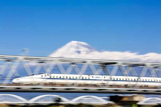 Rychlovlak Shinkansen Tokaido projíždí v roce 2016 mostem s pozadím hory Fudži, Japonsko.