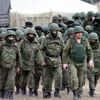 Uniformed men, believed to be Russian servicemen, march outside a Ukrainian military base in the village of Perevalnoye outside Simferopol