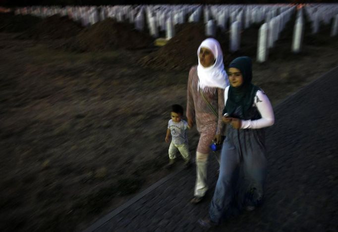 Bosnian Muslims walk during twilight through Memorial Center in Potocari where there will be a mass burial, near Srebrenica July 9, 2012. The bodies of 520 recently identified victims of the Srebrenica massacre will be buried on July 11, the anniversary of the massacre when Bosnian Serb forces commanded by Ratko Mladic slaughtered 8,000 Muslim men and boys and buried them in mass graves, in Europe's worst massacre since World War Two. REUTERS/Dado Ruvic (BOSNIA - Tags: POLITICS CONFLICT ANNIVERSARY) Published: Čec. 9, 2012, 7:46 odp.