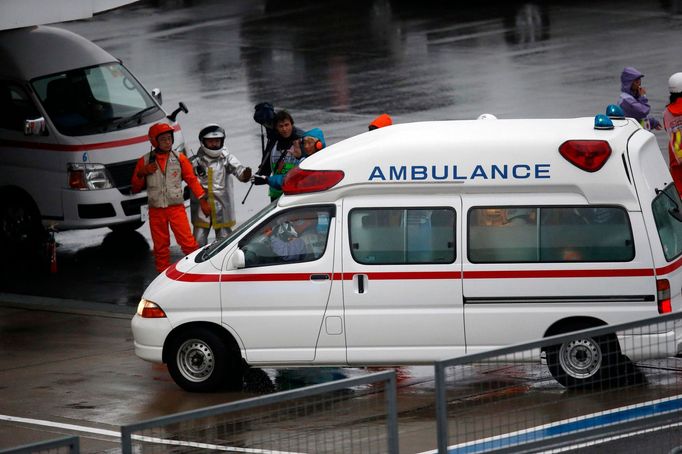 Marshalls clear the way for an ambulance after the race was stopped following a crash by Marussia Formula One driver Jules Bianchi of France at the Japanese F1 Grand Prix