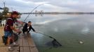 Krisztian Peter (L) and Norbert Barati (C) of Hungary catch a carp during the 14th Carpfishing World Championship in Corbu village, 310 km (192 miles) east of Bucharest, September 29, 2012. REUTERS/Radu Sigheti (ROMANIA - Tags: SOCIETY) Published: Zář. 29, 2012, 4:27 odp.