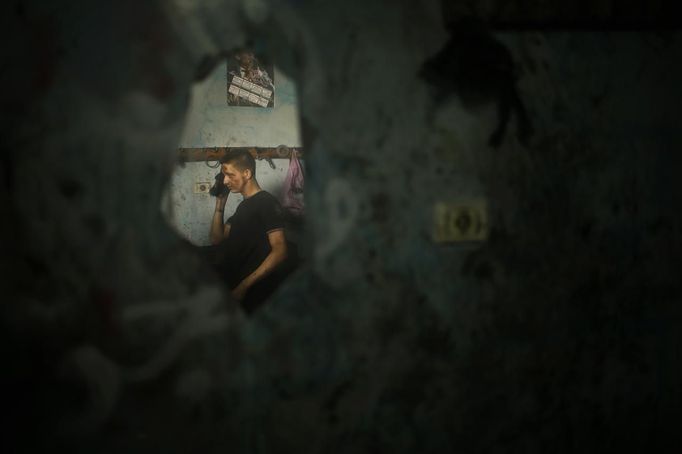 Palestinian Ali al-Batniji (R), 18, is reflected in a mirror as he works in a car repair garage in Gaza City May 30, 2013. Al-Batniji left school to work as an apprentice in the garage so that he could support his family's income. Apprentice mechanics earn around $100 per month, garage owners said. REUTERS/Mohammed Salem (GAZA - Tags: TRANSPORT SOCIETY EMPLOYMENT) Published: Kvě. 30, 2013, 12:54 odp.