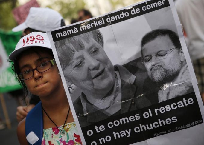 A girl holds a poster depicting German Chancellor Angela Merkel as the mother of Spanish Prime Minister Mariano Rajoy during a protest against government austerity measures in central Madrid July 19, 2012. A protest movement against the centre-right Spanish government's latest austerity measures swelled on Thursday as public sector workers stepped up demonstrations in Madrid and around the country after more than a week of spontaneous action. The poster reads: "Mom Merkel feeding: Either you eat up the bailout or there are no sweets for you". REUTERS/Susana Vera (SPAIN - Tags: CIVIL UNREST BUSINESS POLITICS)