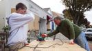 A father and son work to cut plywood sheets in preparation for the arrival of Hurricane Sandy in Westhampton Beach, New York, October 28, 2012. Hurricane Sandy could be the biggest storm to hit the United States mainland when it comes ashore on Monday night, bringing strong winds and dangerous flooding to the East Coast from the mid-Atlantic states to New England, forecasters said on Sunday. REUTERS/Lucas Jackson (UNITED STATES - Tags: ENVIRONMENT DISASTER)