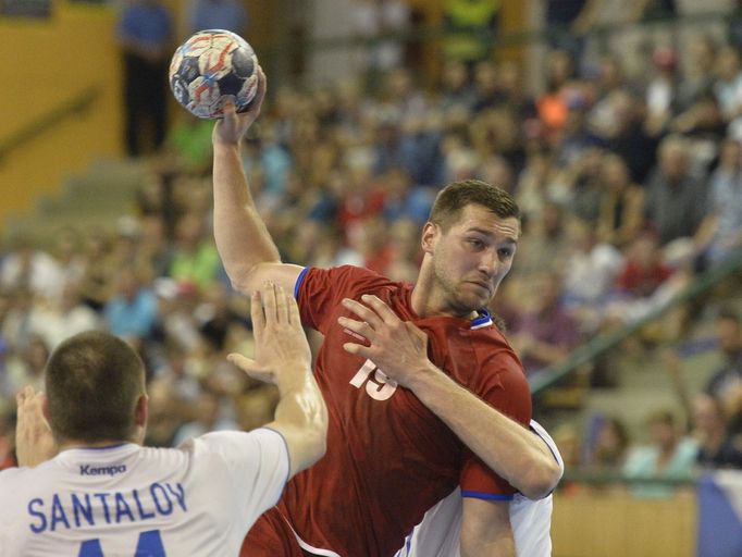 Dmitrij Santalov z Ruska a český hráč Tomáš Babák v úvodním utkání play off kvalifikace mistrovství světa házenkářů