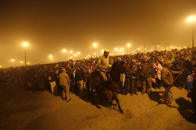 A policeman mounted on his horse maintains order during the first "Shahi Snan" (grand bath) at the ongoing "Kumbh Mela", or Pitcher Festival, in the northern Indian city of Allahabad January 14, 2013. Upwards of a million elated Hindu holy men and pilgrims took a bracing plunge in India's sacred Ganges river to wash away lifetimes of sins on Monday, in a raucous start to an ever-growing religious gathering that is already the world's largest. REUTERS/Ahmad Masood (INDIA - Tags: RELIGION SOCIETY ANIMALS TPX IMAGES OF THE DAY) Published: Led. 14, 2013, 2:05 odp.