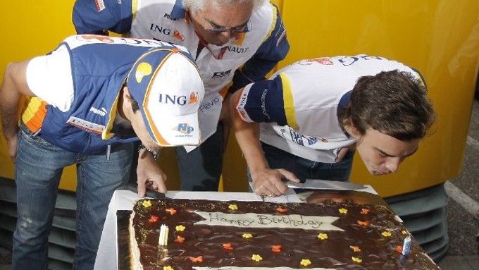 Piloti Renaultu Fernando Alonso (vpravo) a Nelsinho Piquet pod dohledem šéfa stáje Flavia Briatoreho sfoukávají svíčky na narozeninovém dortu.