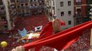 Revellers on the town hall balcony hold up red scarves during the start of the San Fermin Festival in Pamplona July 6, 2012. The festival, best known for its daily running of the bulls, kicked off on Tuesday with the traditional "Chupinazo" rocket launch and will run until July 14. REUTERS/Vincent West (SPAIN - Tags: SOCIETY) Published: Čec. 6, 2012, 11:53 dop.