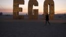 Ruth Kidd explores the art piece "Ego" before sunrise during the Burning Man 2012 "Fertility 2.0" arts and music festival in the Black Rock Desert of Nevada, August 29, 2012. More than 60,000 people from all over the world have gathered at the sold out festival, which is celebrating its 26th year, to spend a week in the remote desert cut off from much of the outside world to experience art, music and the unique community that develops.