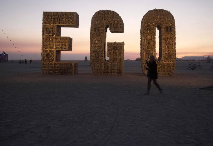 Ruth Kidd explores the art piece "Ego" before sunrise during the Burning Man 2012 "Fertility 2.0" arts and music festival in the Black Rock Desert of Nevada, August 29, 2012. More than 60,000 people from all over the world have gathered at the sold out festival, which is celebrating its 26th year, to spend a week in the remote desert cut off from much of the outside world to experience art, music and the unique community that develops.