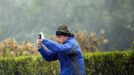 A man blown by wind from Hurricane Sandy attempts to take pictures of the storm in Southampton, New York, October 29, 2012. Hurricane Sandy, the monster storm bearing down on the East Coast, strengthened on Monday after hundreds of thousands moved to higher ground, public transport shut down and the stock market suffered its first weather-related closure in 27 years. REUTERS/Lucas Jackson (UNITED STATES - Tags: ENVIRONMENT DISASTER) Published: Říj. 29, 2012, 5:53 odp.