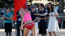 Catherine, Britain's Duchess of Cambridge, directs a young surf lifesaver to the finish line during a contest at a surf lifesaving demonstration at Sydney's Manly beach