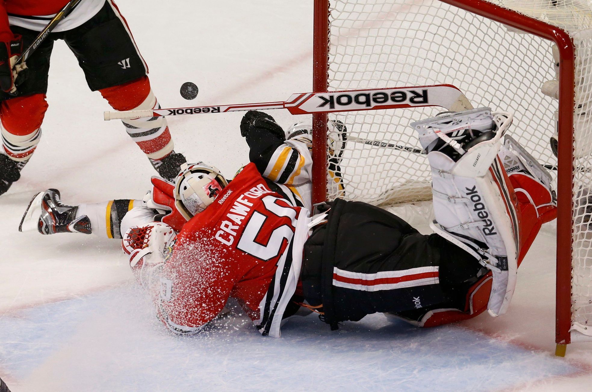 Bruins' Paille collides with Blackhawks goalie Crawford duri