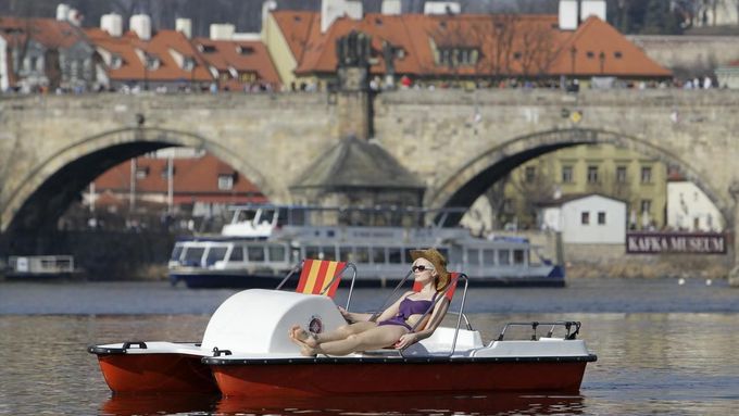 Žena si užívá sobotní slunečné odpoledne na šlapadle na Vltavě v centru Prahy.