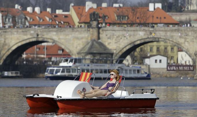 Žena si užívá sobotní slunečné odpoledne na šlapadle na Vltavě v centru Prahy.