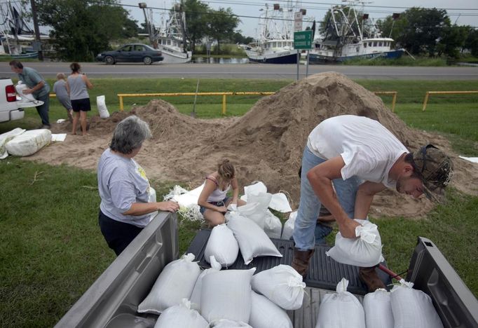 Jonathan Sellers (right) loads sandbags with his relatives at a local government sandbag distribution point as they prepare for the arrival of Tropical Storm Isaac in Chauvin. Louisiana August 27, 2012. REUTERS/Lee Celano (UNITED STATES - Tags: ENVIRONMENT DISASTER) Published: Srp. 28, 2012, 12:06 dop.