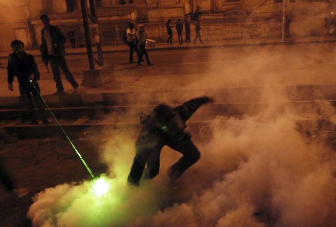 A protester, who opposes Egyptian President Mohamed Mursi, throws a tear gas canister, which was thrown earlier by the riot police, during clashes in front of the presidential palace in Cairo February 11, 2013. Protesters demanding the departure of Egyptian President Mohamed Mursi clashed with police outside his palace on Monday on the second anniversary of the overthrow of veteran autocrat Hosni Mubarak. REUTERS/Amr Abdallah Dalsh (EGYPT - Tags: POLITICS CIVIL UNREST) Published: Úno. 11, 2013, 11:57 odp.