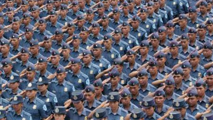Muži a ženy v uniformách Filipínské národní policie (PNP) se šikují předtím, než budou vysláni dohlížet na bezpečnost nadcházejících voleb