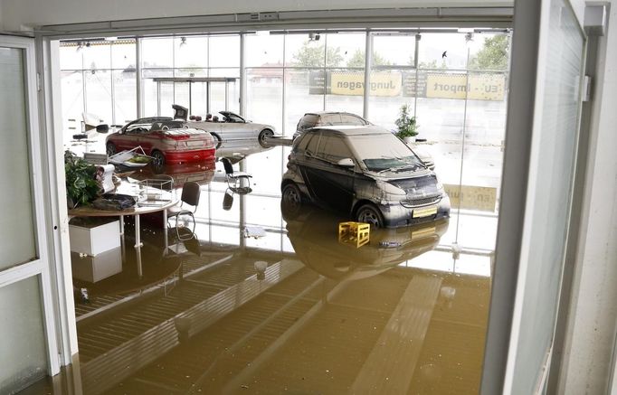 s stand in the subsiding floods of the Danube river at the showroom of car dealership in Fischerdorf, a suburb of the eastern Bavarian city of Deggendorf June 10, 2013. Tens of thousands of people have been forced to leave their homes and there have been at least a dozen deaths as a result of floods that have hit Germany, Austria, Slovakia, Poland and the Czech Republic over the past week. REUTERS/Wolfgang Rattay (GERMANY - Tags: DISASTER TRANSPORT)