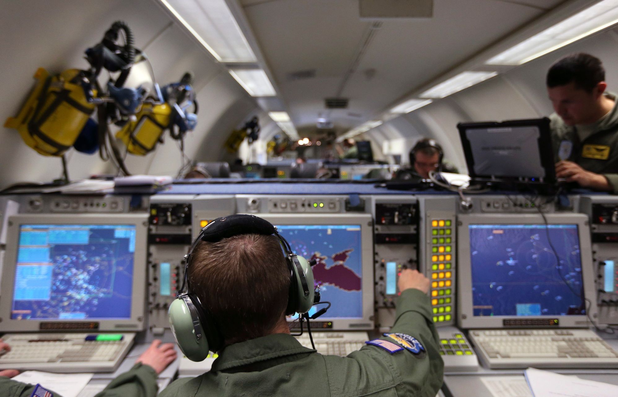 A controller sits at screens aboard a NATO AWACS aircraft during a surveillance flight over Romania
