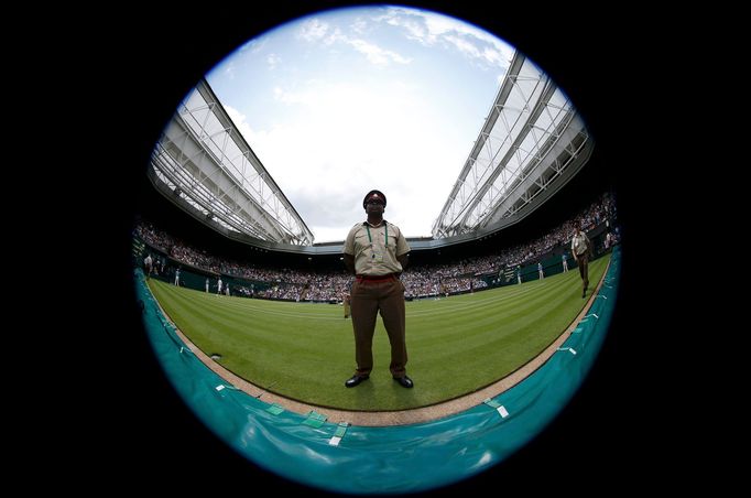 A soldier stands on Centre Court at the Wimbledon Tennis Championships, in London June 25, 2013. Photograph taken with a fish-eye lens. REUTERS/Eddie Keogh (BRITAIN - Tag