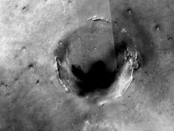 Opportunity Amid Mars Craters (Unannotated) This map of the region around NASA's Mars Exploration Rover Opportunity shows the relative locations of several craters, including Endeavour. A super-resolution view generated from images taken by Opportunity on May 12, 2010, (http://www.nasa.gov/mission_pages/mer/multimedia/gallery/pia13197-unlabeled.html) shows some detail in a portion of Endeavour's rim. The map covers an area about 55 kilometers (34 miles) across in the Meridiani Planum region of Mars. It is a mosaic of images from the Context Camera on NASA's Mars Reconnaissance Orbiter. North is toward the top. Opportunity's explorations have all been within the upper left quadrant of the region covered in this map. Opportunity explored Endurance Crater (barely visible about 7 kilometers or 4 miles from the left edge of this area and 2 kilometers or 1 mile from the top) during the first year after the rover's January 2004 arrival on Mars for a mission originally scheduled to last for three months. Since the summer of 2008, when Opportunity finished two years of studying Victoria Crater (about 8 kilometers or 5 miles from the left edge and 9 kilometers or 6 miles from the top), the rover's long-term destination has been the much larger Endeavour Crater (the large crater at the center). By the spring of 2010, Opportunity had covered more than a third of the charted, 19-kilometer (12-mile) route from Victoria to Endeavour and reached an area with a gradual, southward slope offering a view of a portion of Endeavour's elevated rim. After the rover team chose Endeavour as a long-term destination, the goal became even more alluring when observations with the Compact Reconnaissance Imaging Spectrometer for Mars, also on the Mars Reconnaissance Orbiter, found clay minerals exposed at Endeavour. James Wray, of Cornell University, and co-authors reported observations of those minerals in Geophysical Research Letters in 2009. Clay minerals, which form under wet and relatively neutral pH conditions, have been found extensively on Mars from orbit but have not been examined on the surface. Additional observations with that spectrometer are helping the rover team choose which part of Endeavour's rim to visit first with Opportunity. The crater at the bottom center of the map is Iazu. Material that was ejected during the impact that excavated Iazu is visible on the horizon in Opportunity's May 12, 2010, view of the Endeavor rim. Image Credit: NASA/JPL-Caltech/Malin Space Science Systems