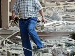 Obyvatel Bejrútu si prohlíží trosky vybombardovaného domu.