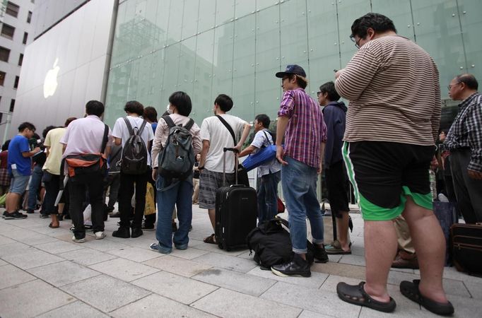 People wait in line outside an Apple store to purchase Apple Inc's iPhone 5 in Tokyo's Ginza district September 21, 2012. Apple Inc's iPhone 5 hit stores around the globe on Friday, with fans snapping up the device that is expected to fuel a huge holiday quarter for the consumer giant. REUTERS/Yuriko Nakao (JAPAN - Tags: BUSINESS SCIENCE TECHNOLOGY) Published: Zář. 21, 2012, 1:46 dop.