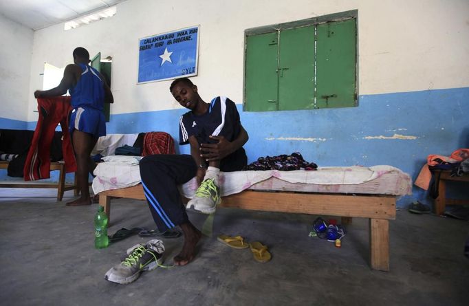 Somali athletes remove their shoes inside their room after a training session as part of their preparations for the 2012 London Olympic Games in Somalia's capital Mogadishu March 14, 2012 file photos. Training in a bullet-riddled stadium where the remains of a rocket propelled grenade lies discarded on the track's edge counts as progress for Somali Olympic hopeful Mohamed Hassan Mohamed. A year ago, Mogadishu's Konis stadium was a base for Islamist militants and a work out meant at times running through the streets, dodging gun-fire and mortar shells in one of the world's most dangerous cities. To match OLY-SOMALIA-HOPES/ REUTERS/Feisal Omar/Files (SOMALIA - Tags: SPORT ATHLETICS SOCIETY OLYMPICS) Published: Čer. 11, 2012, 6:47 dop.