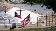 Texas přitom letos již několik povodní zažil, v červnu ve městě San Antonio zahynulo 13 lidí. Na snímku jsou kříže a vlajky u památníku obětem povodní u řeky Guadalupe.