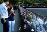 K památníku teroristického útoku v New Yorku po celý den přicházejí lidé uctít památku obětí a zavzpomínat na ty, které 11. září 2001 ztratili.