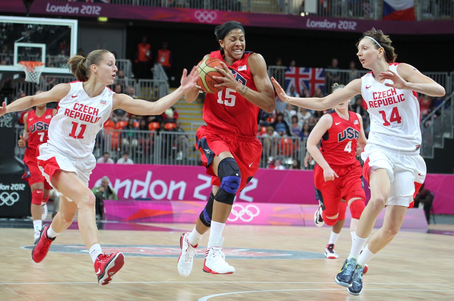 České basketbalistky Kateřina Elhotová (vlevo) a Tereza Pecková se snaží bránit unikající Američanku Candace Parkerovou v utkání skupiny A na OH 2012 v Londýně.