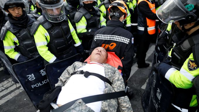 Záchranář odváží jednoho ze zraněných protestujících.