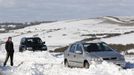 A man waits by a car stuck in snow on the South Downs near Brighton in southern England March 12, 2013. Drivers were left stranded on Tuesday following a second day of heavy snowfall in southern England. REUTERS/Luke MacGregor (BRITAIN - Tags: ENVIRONMENT SOCIETY) Published: Bře. 12, 2013, 4:58 odp.