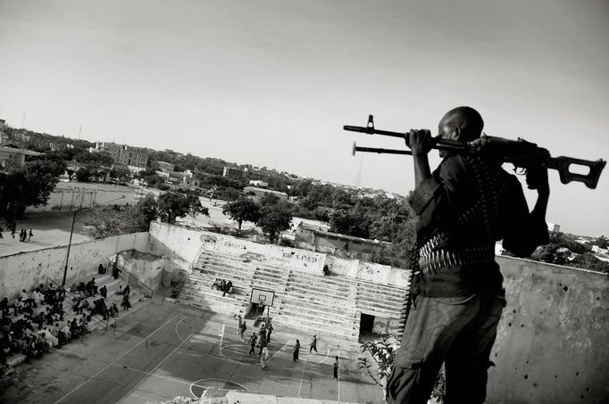 ATTENTION EDITORS - PICTURE 8 OF 18 OF THE WINNERS OF THE 56th WORLD PRESS PHOTO CONTEST 2013 Jan Grarup of Denmark, a photographer working for Laif Agency, has won the first prize in the Sports Features Stories category of the World Press Photo Contest 2013 with the series "Women's Basketball, Mogadishu, Somalia". The picture shows an armed guard, paid by the Somali basketball association, watching over and protecting a women's basketball team as they play in Mogadishu, taken on February 21, 2012 and distributed by the World Press Photo Foundation February 15, 2013. The prize-winning entries of the World Press Photo Contest 2013, the world's largest annual press photography contest, were announced today, February 15, 2013. REUTERS/Jan Grarup/Laif/World Press Photo/Handout (SOMALIA - Tags: CIVIL UNREST SPORT BASKETBALL SOCIETY MEDIA) ATTENTION EDITORS - THIS IMAGE WAS PROVIDED BY A THIRD PARTY. FOR EDITORIAL USE ONLY. NOT FOR SALE FOR MARKETING OR ADVERTISING CAMPAIGNS. THIS PICTURE IS DISTRIBUTED EXACTLY AS RECEIVED BY REUTERS, AS A SERVICE TO CLIENTS. NO SALES. NO ARCHIVES. Published: Úno. 15, 2013, 10:15 dop.