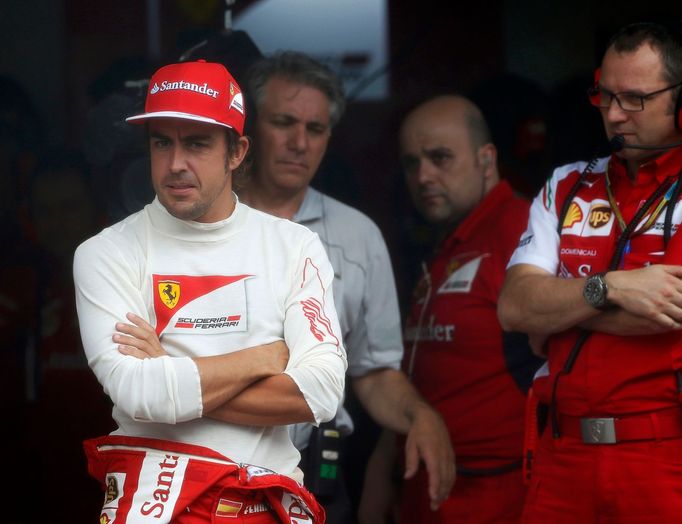 Ferrari Formula One driver Fernando Alonso of Spain waits out the rain in his team garage before the the qualifying session for the Malaysian F1 Grand Prix at Sepang Inte